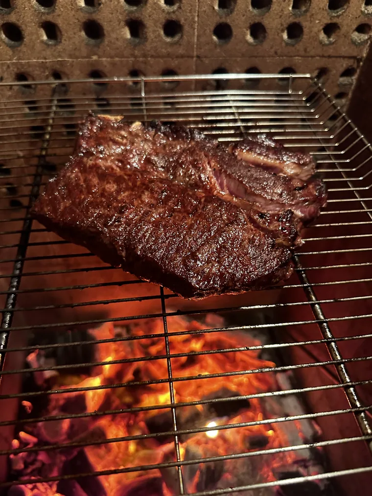 Steak over charcoal on a grill