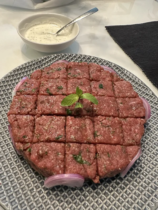 Homemade kibbeh served with a creamy sauce
